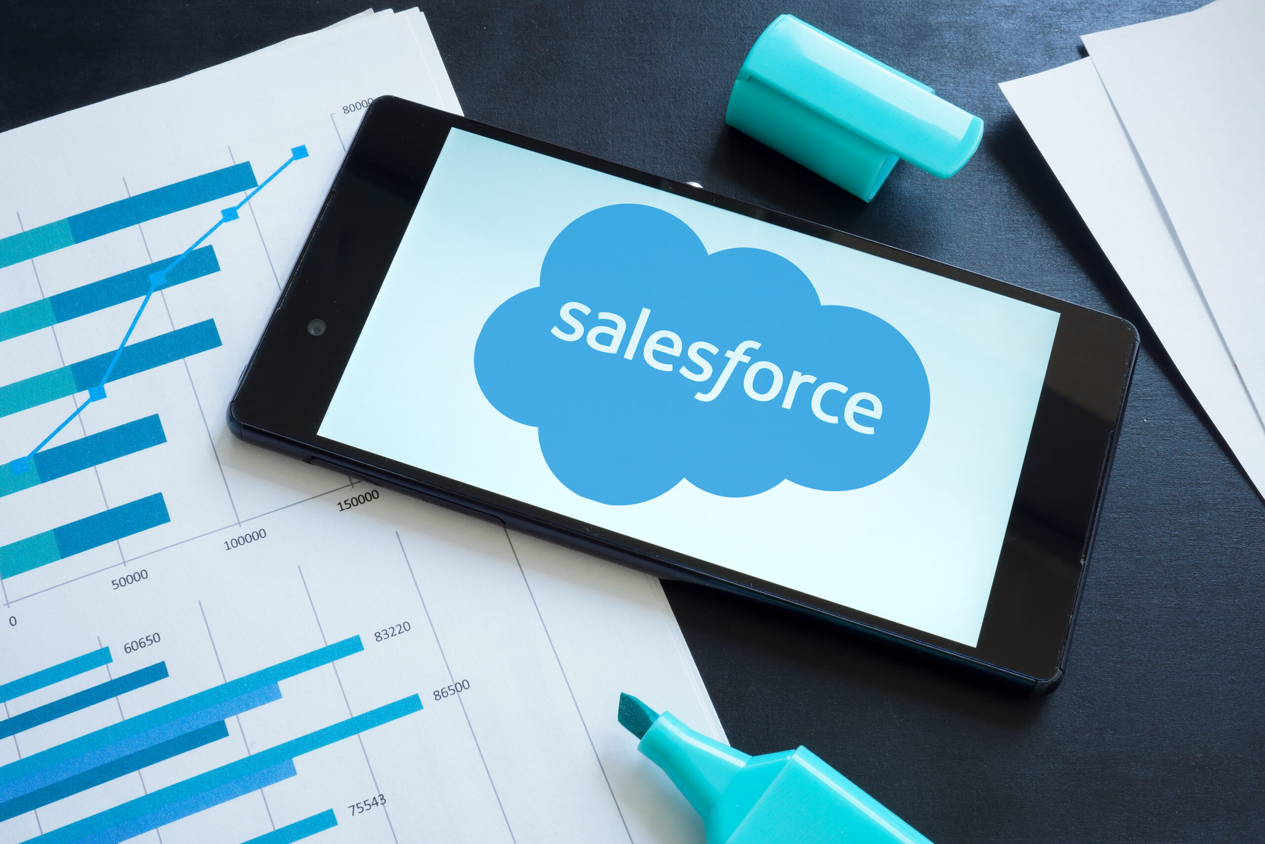 Salesforce logo on the smartphone and papers.