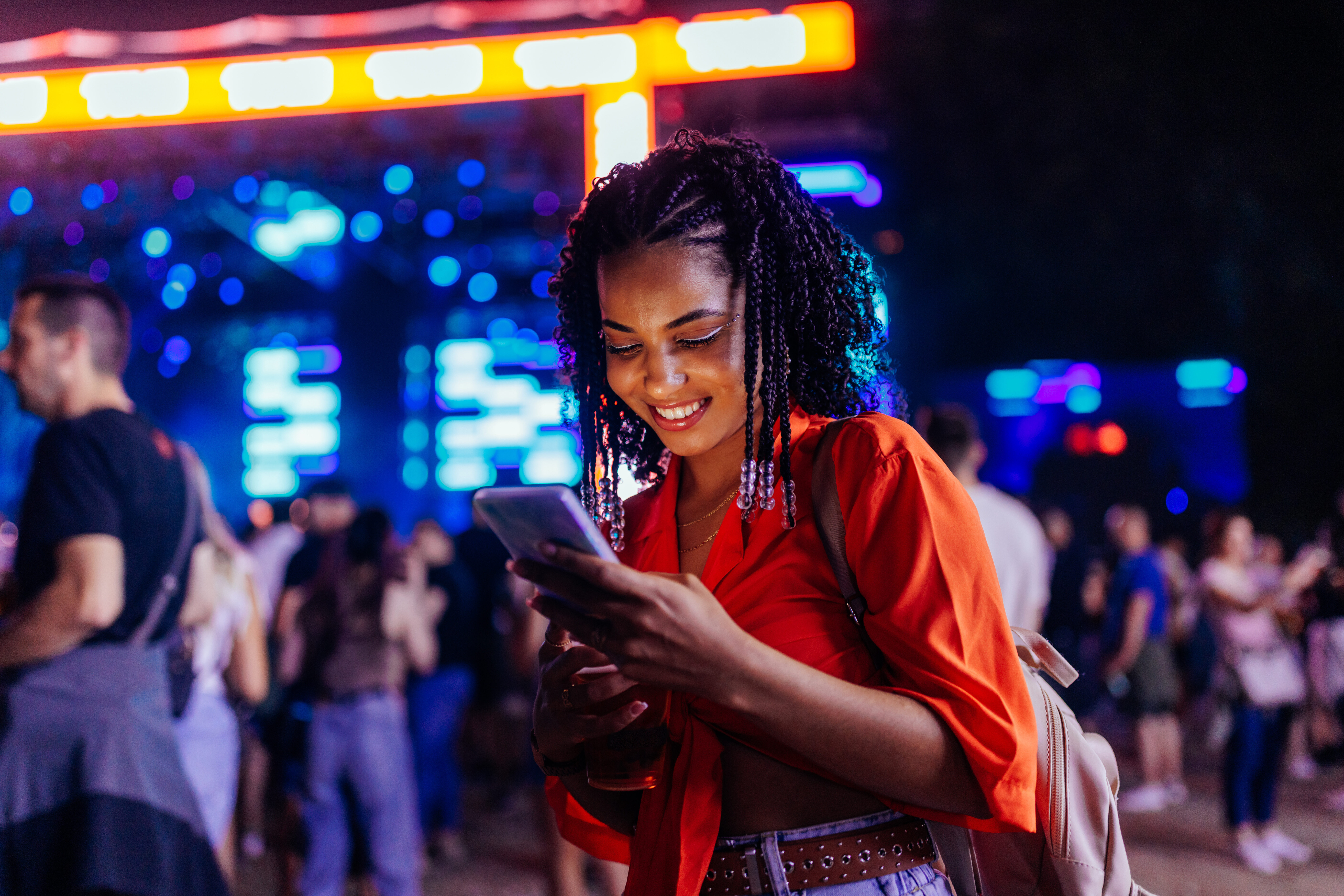 Young girl with smartphone at music festival