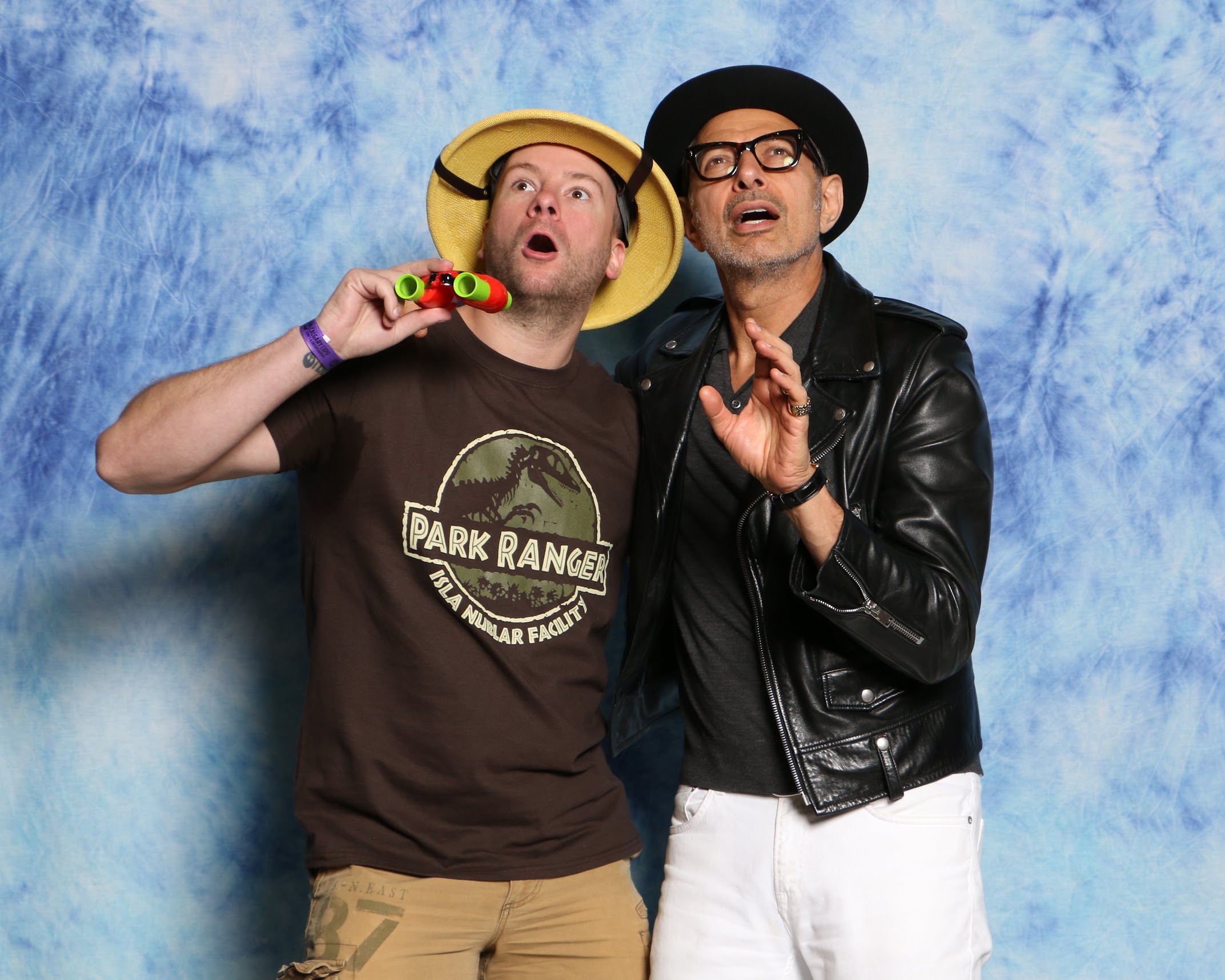 Jeff Goldblum posing with a fan, who is wearing Jurassic Park gear