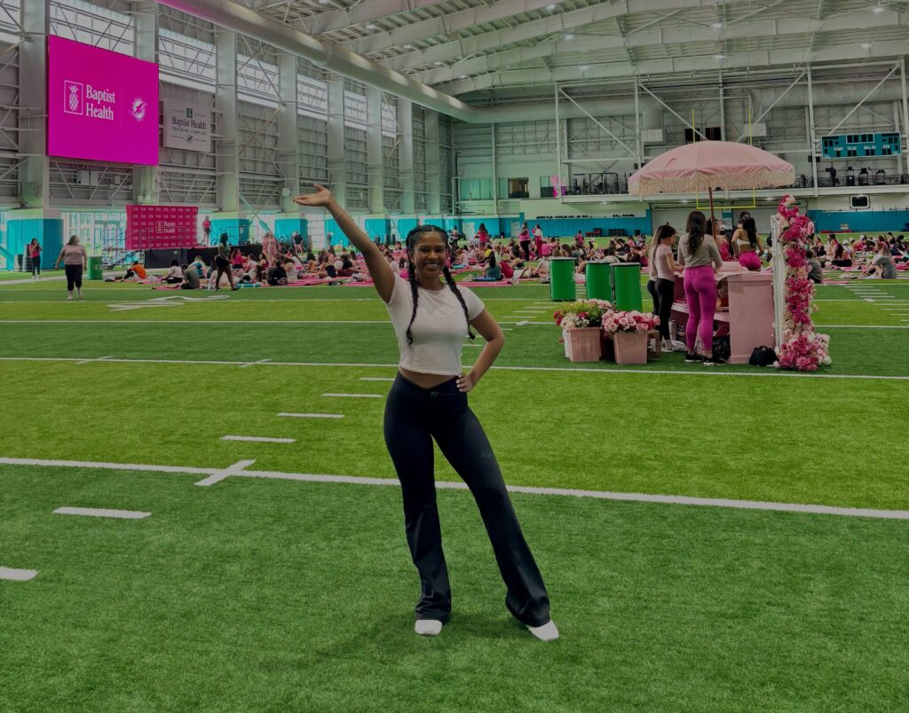 Ariana Singh at a live event on an indoor sports field with lots of pink decorations